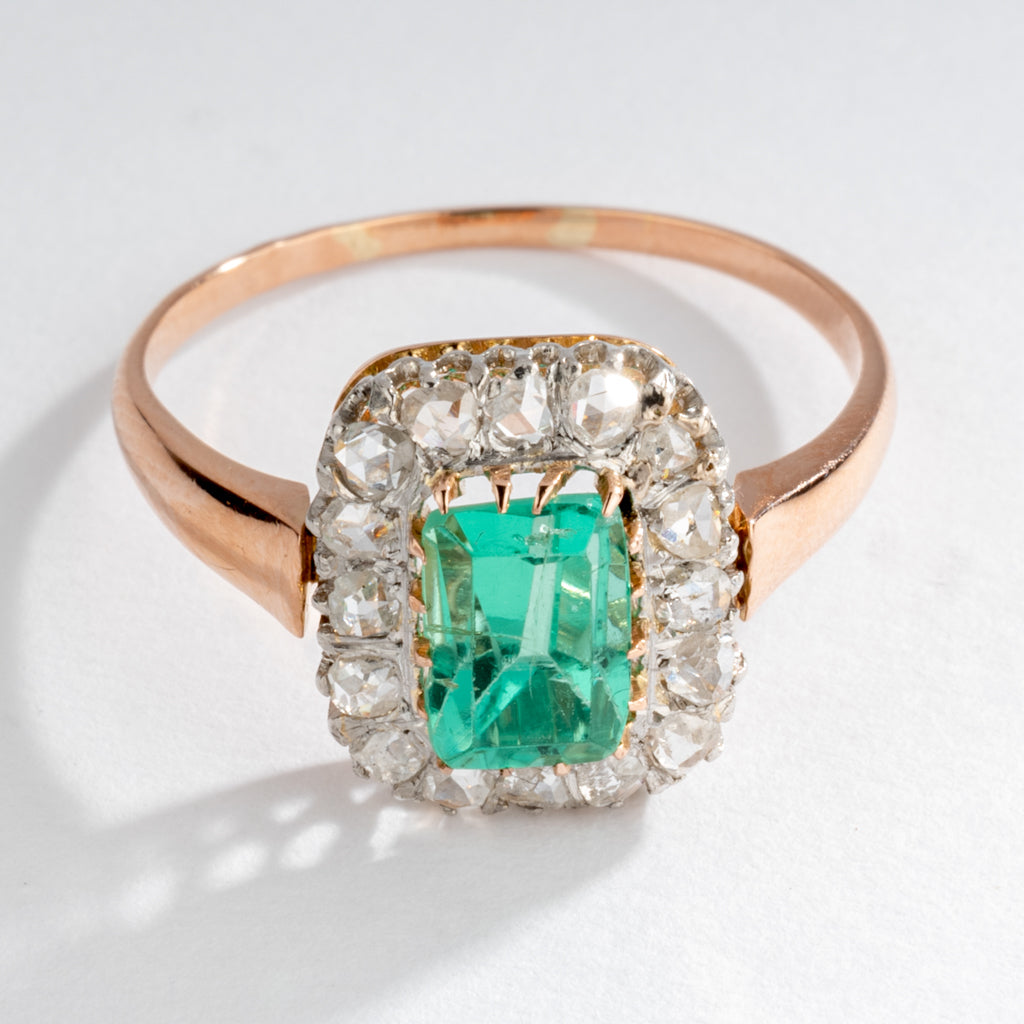 Bague entourage émeraude et diamant.