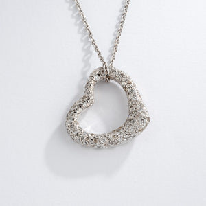 Pendentif en or gris formant un cœur pavée de diamants