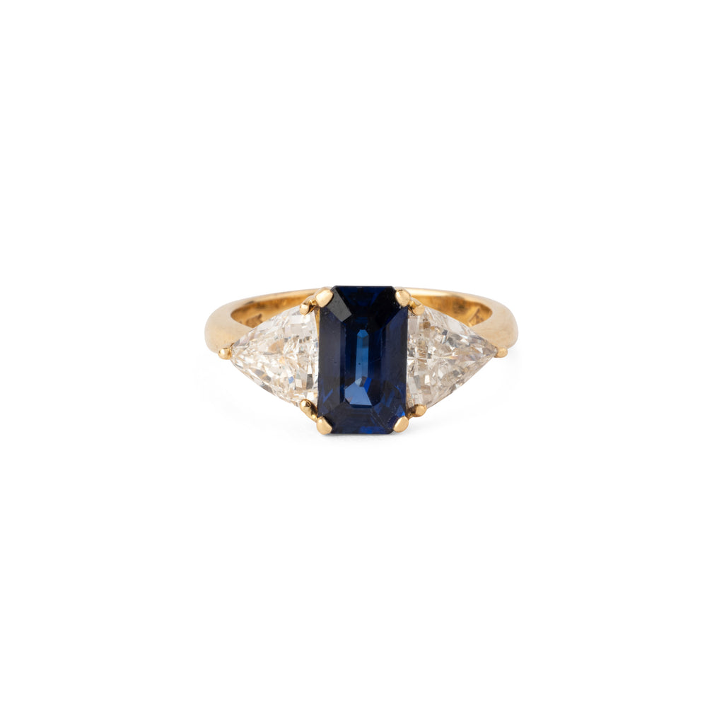 Emerald-cut sapphire ring flanked by two triangular-cut diamonds
