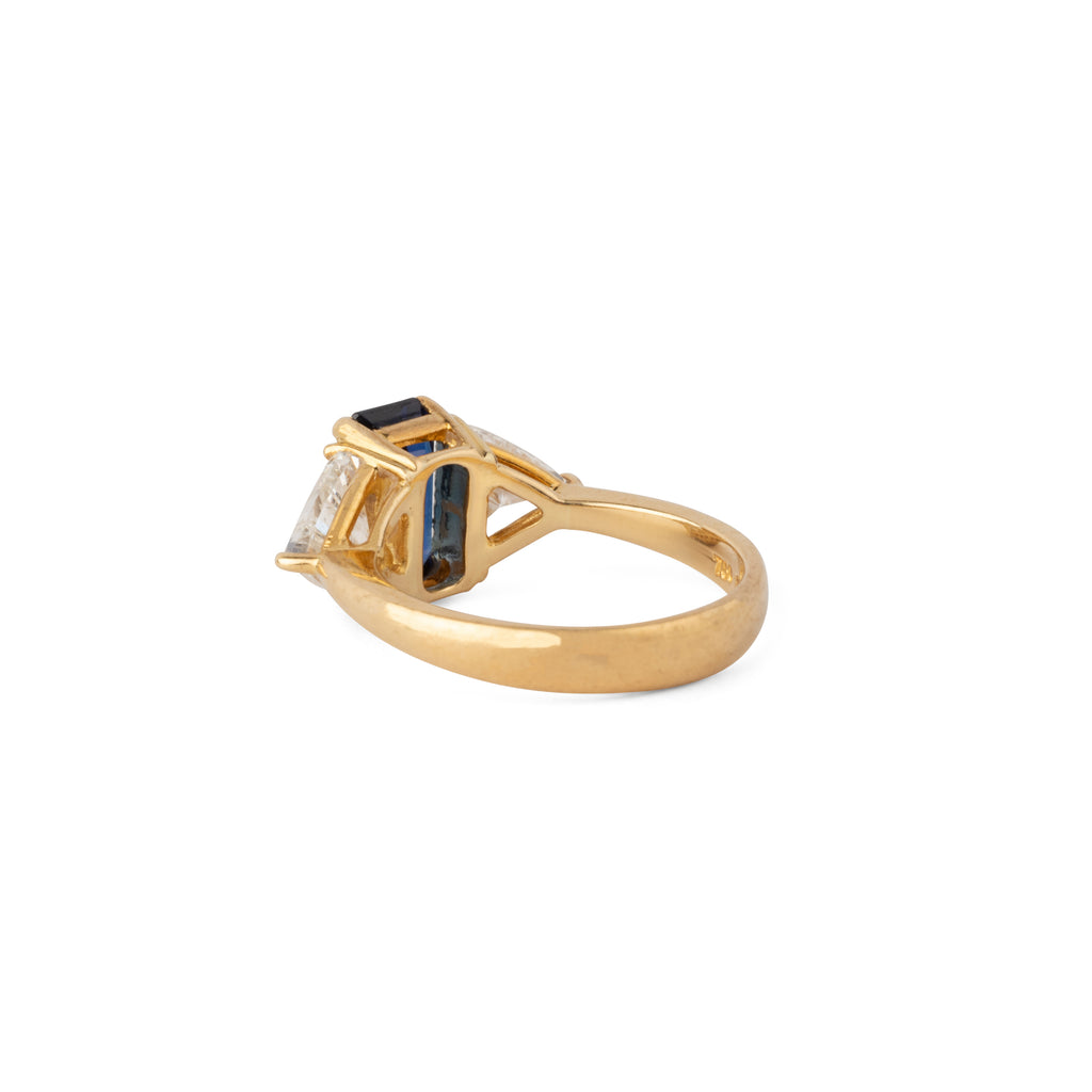 Emerald-cut sapphire ring flanked by two triangular-cut diamonds