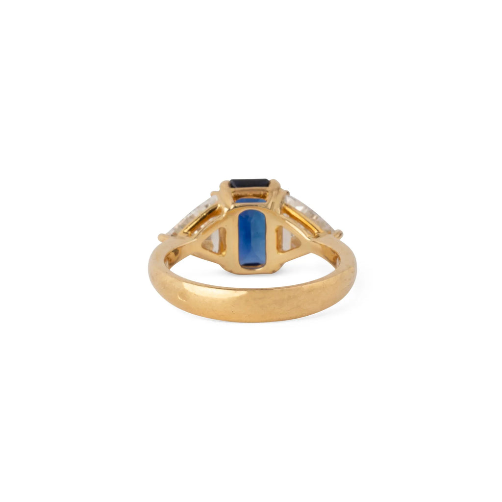Emerald-cut sapphire ring flanked by two triangular-cut diamonds