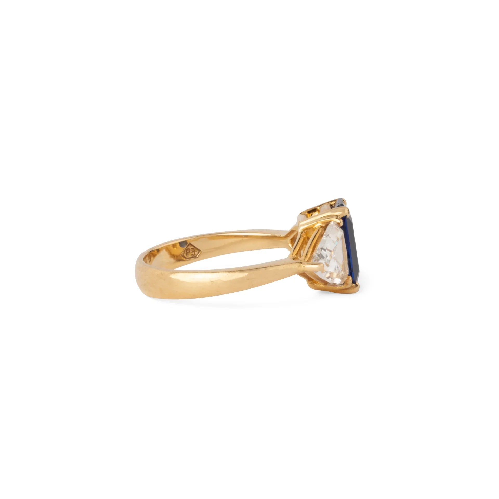 Emerald-cut sapphire ring flanked by two triangular-cut diamonds