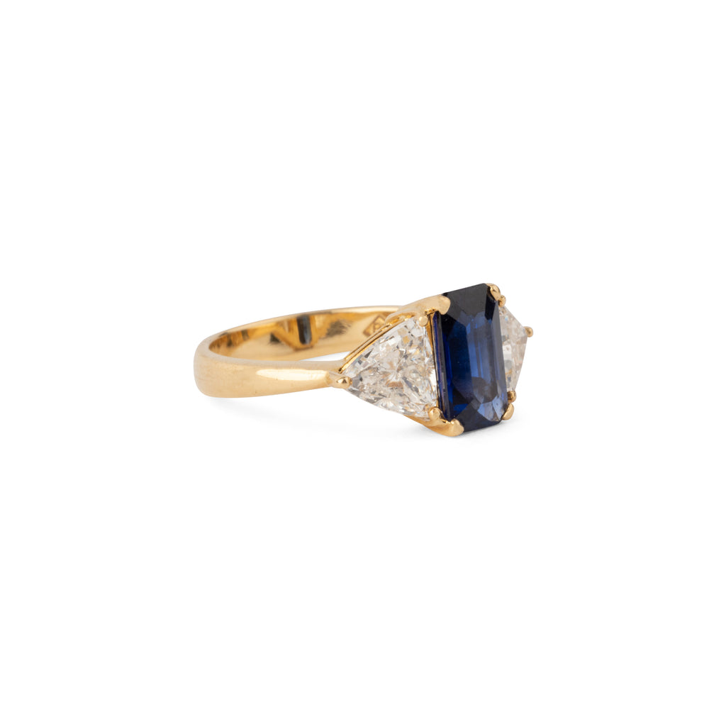 Emerald-cut sapphire ring flanked by two triangular-cut diamonds