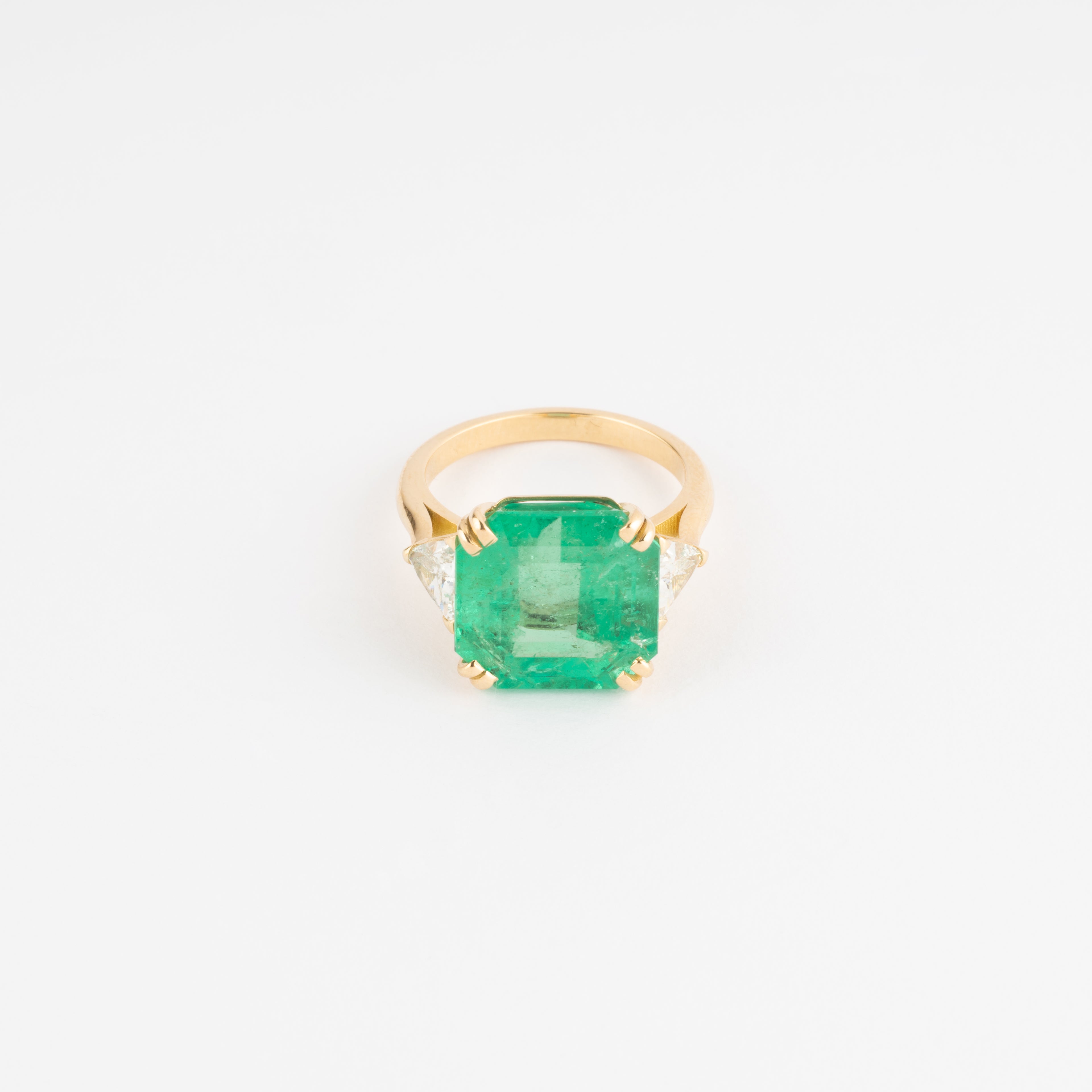 Bague en or jaune ornée d'une émeraude taille émeraude épaulé de diamants triangles