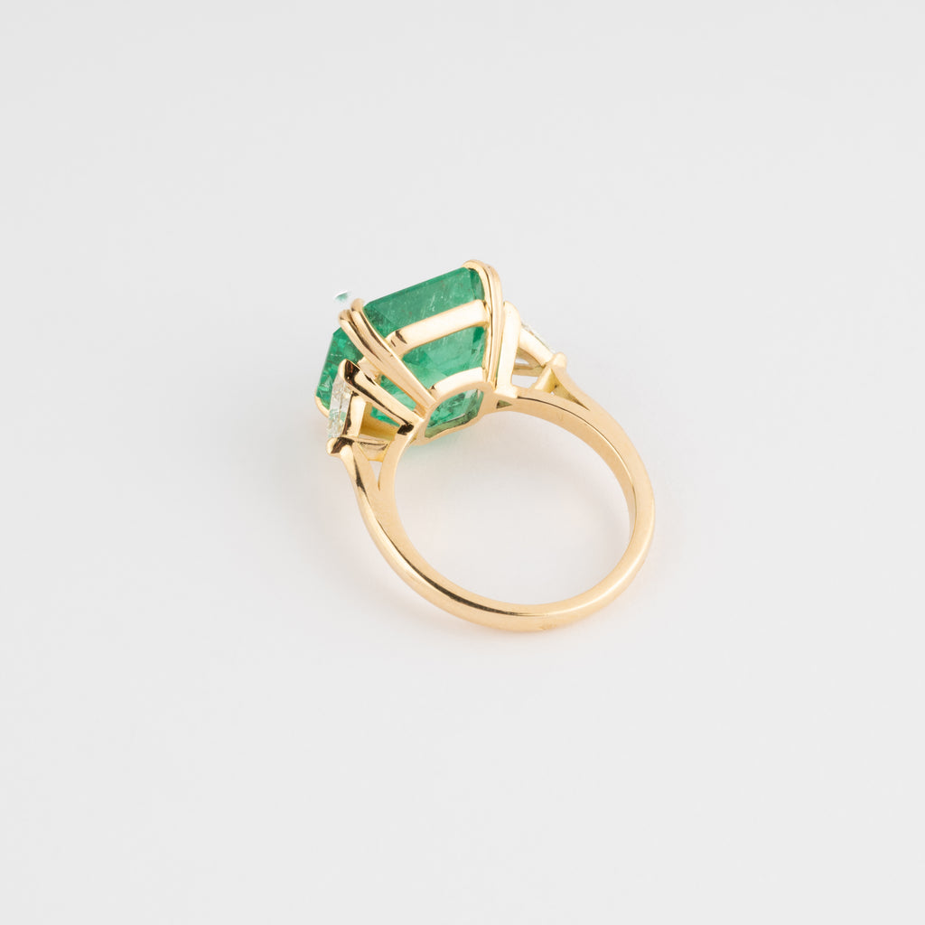 Bague en or jaune ornée d'une émeraude taille émeraude épaulé de diamants triangles