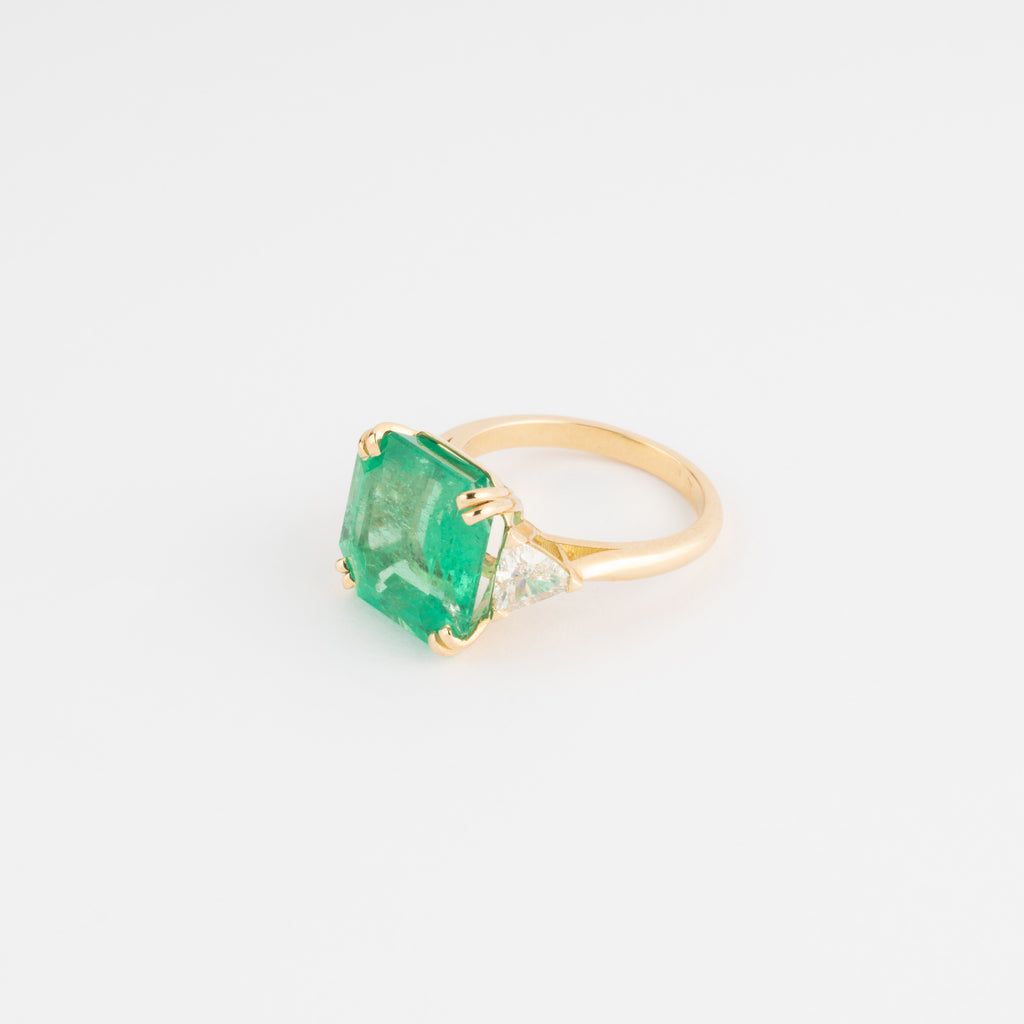 Bague en or jaune ornée d'une émeraude taille émeraude épaulé de diamants triangles