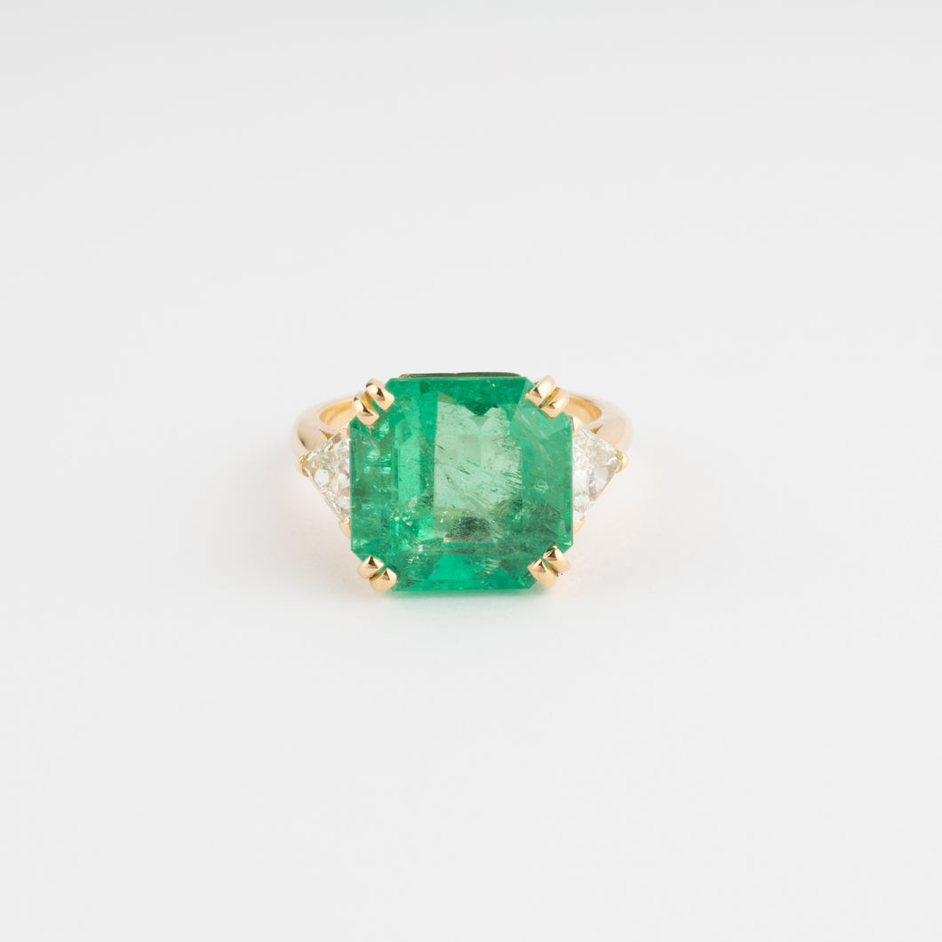 Bague en or jaune ornée d'une émeraude taille émeraude épaulé de diamants triangles