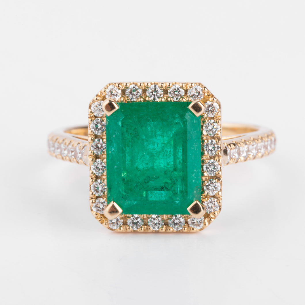 Bague en or jaune ornée d'une émeraude entourée de diamants