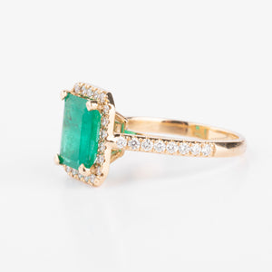 Bague en or jaune ornée d'une émeraude entourée de diamants