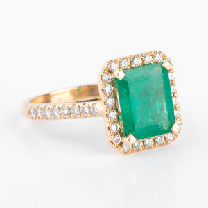 Bague en or jaune ornée d'une émeraude entourée de diamants