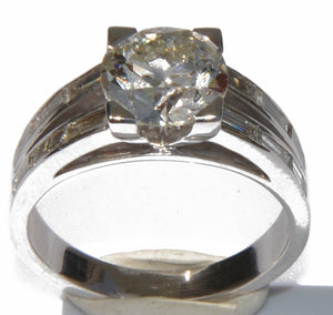 Bague solitaire ornée d'un diamant épaulée de diamant taille baguette