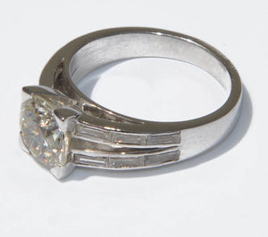 Bague solitaire ornée d'un diamant épaulée de diamant taille baguette