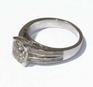 Bague solitaire ornée d'un diamant épaulée de diamant taille baguette