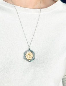 Médaille ajourée en or gris et diamant représentent la vierge et l'enfant