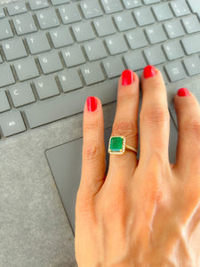 Bague en or jaune ornée d'une émeraude entourée de diamants