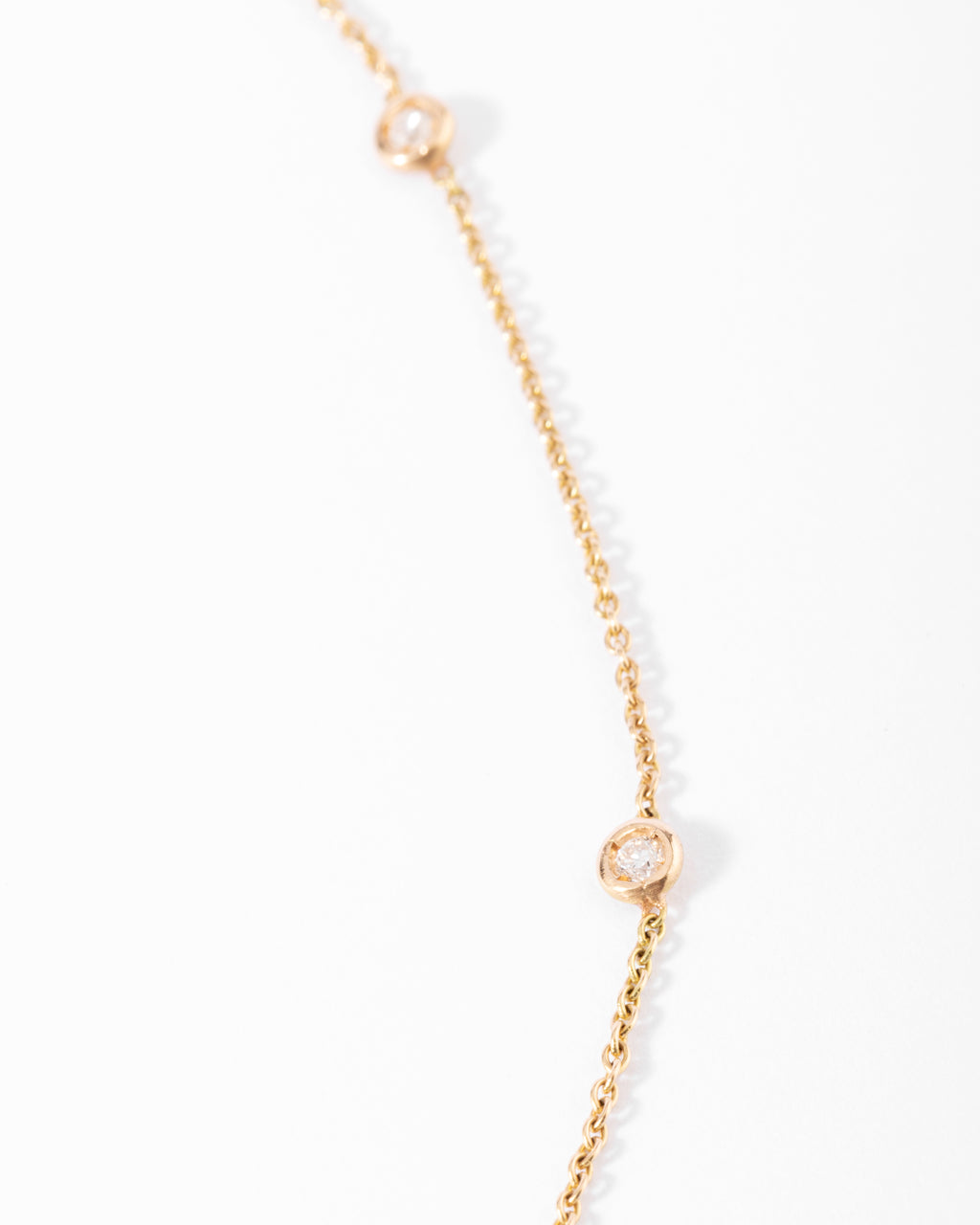 Collier or jaune intercalé de 9 diamants sur maille forçat en sertis clos.